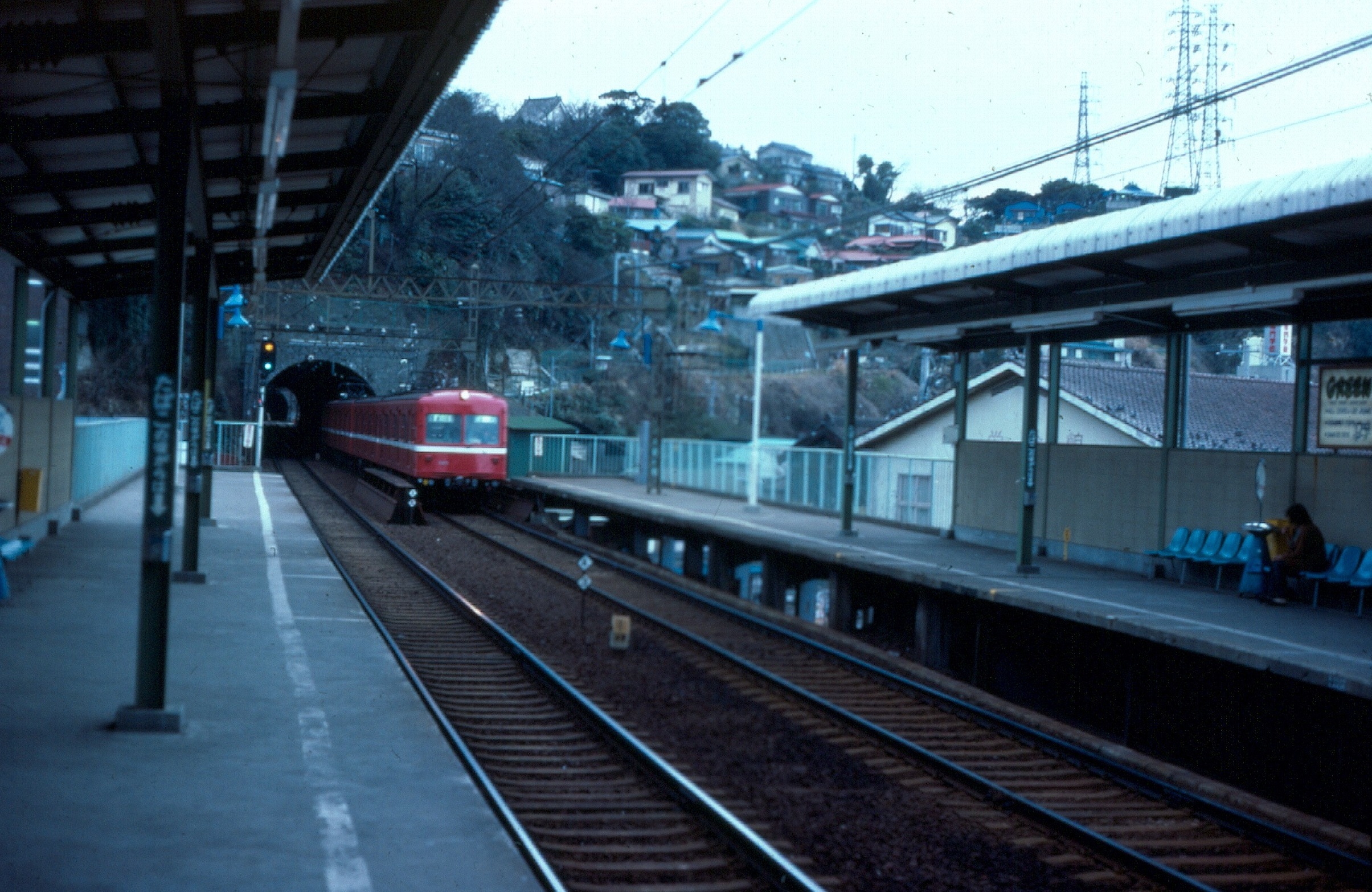 A red train leaving a tunnel into an empty platform